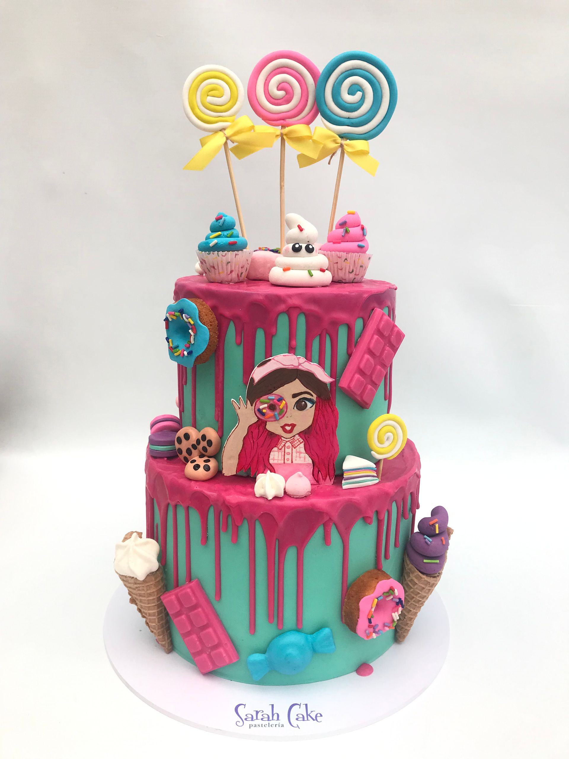 Un pastel con una muñeca encima y dulces encima.