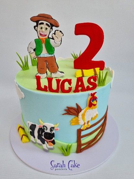 Un pastel de cumpleaños para Lucas con una vaca y un pollo encima.