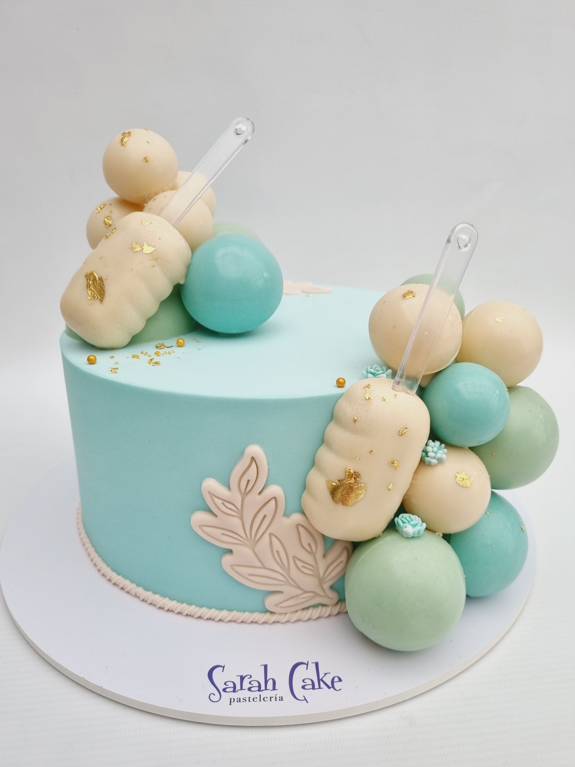 Un pastel azul con bolas blancas y verdes encima.