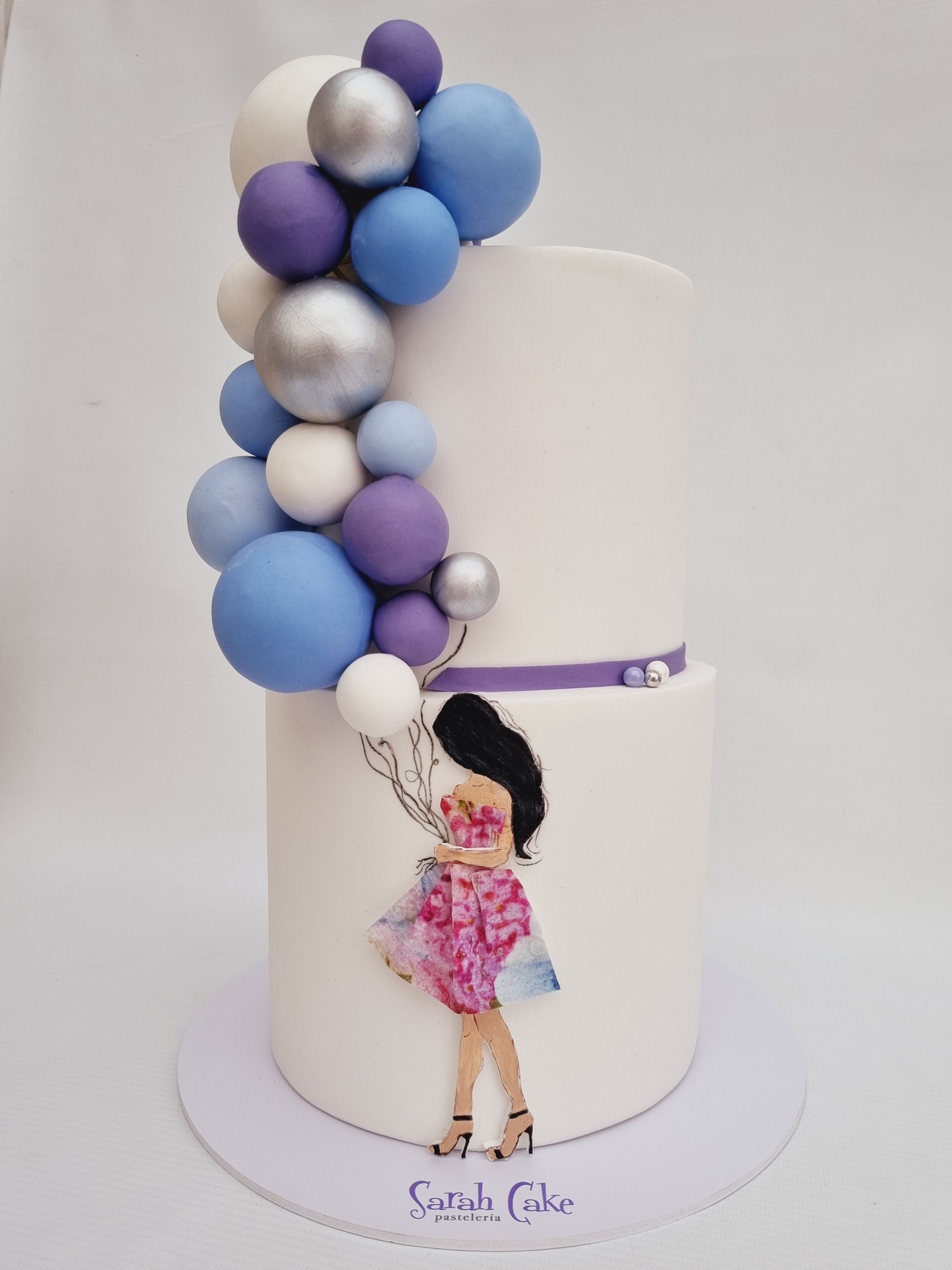 Un pastel con la imagen de una niña sosteniendo globos.