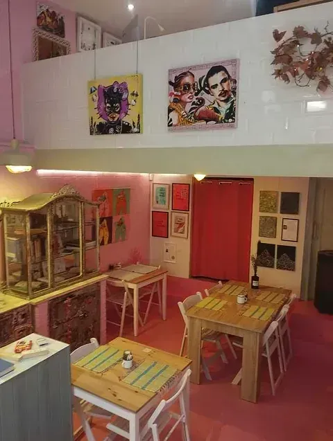 Una habitación con mesas y sillas y cuadros en la pared.
