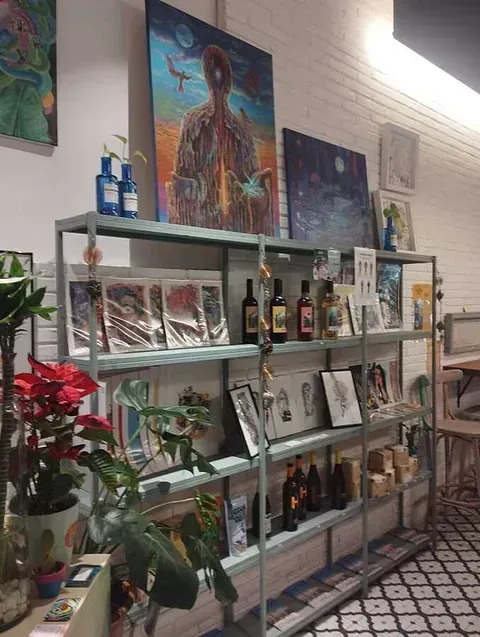 Una habitación con muchos estantes y cuadros en la pared.