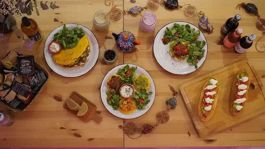Una mesa de madera cubierta con platos de comida y una tabla de cortar.