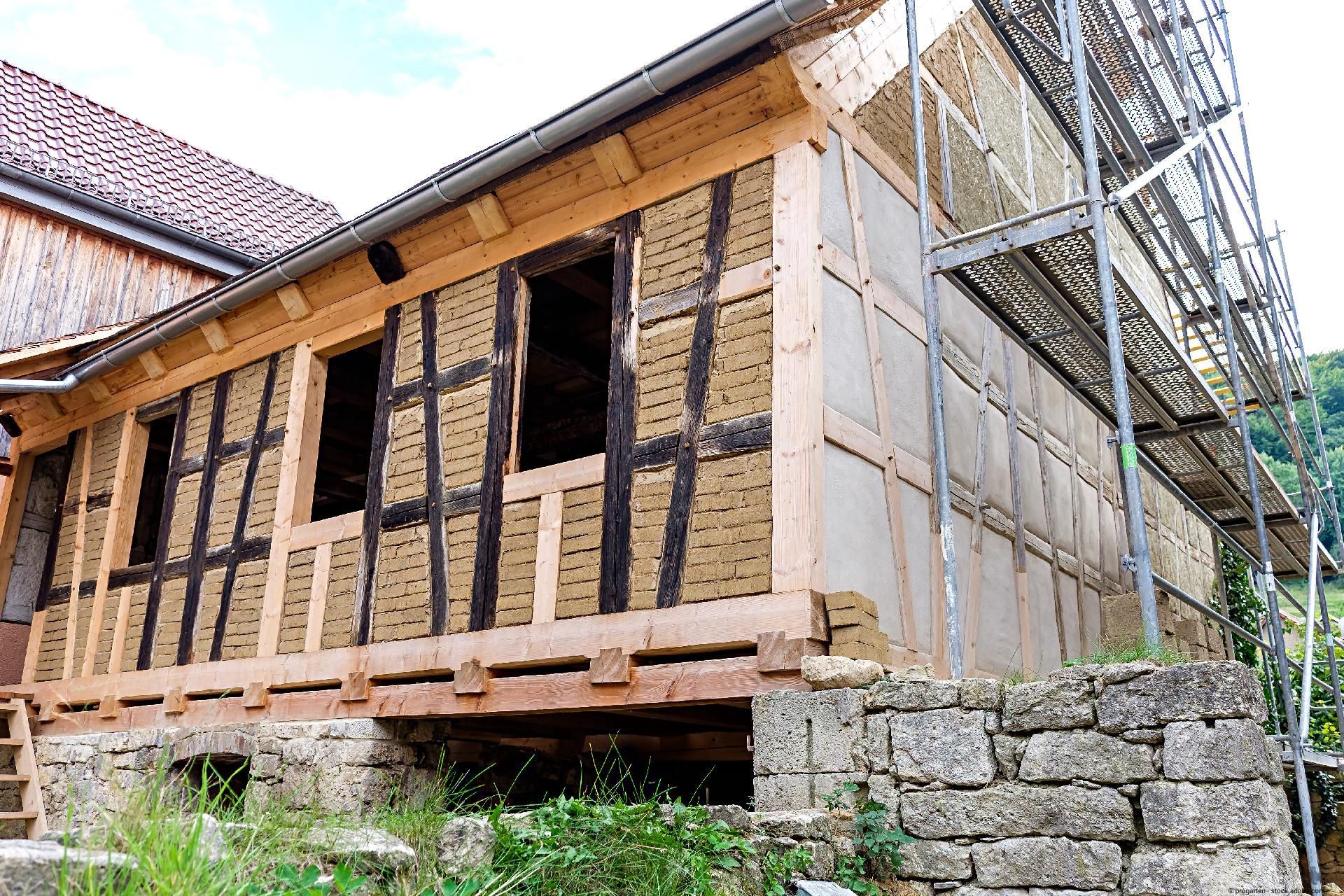 Sanierung eines Fachwerkhauses mit freigelegter Holzkonstruktion und Dämmung