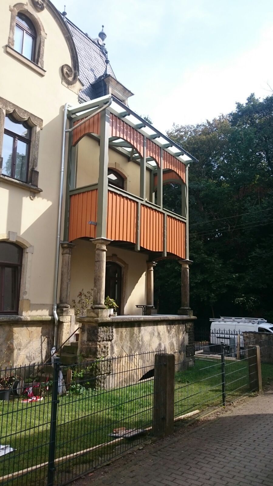 Detailansicht eines sanierten Balkons mit Holzverkleidung an Altbaufassade