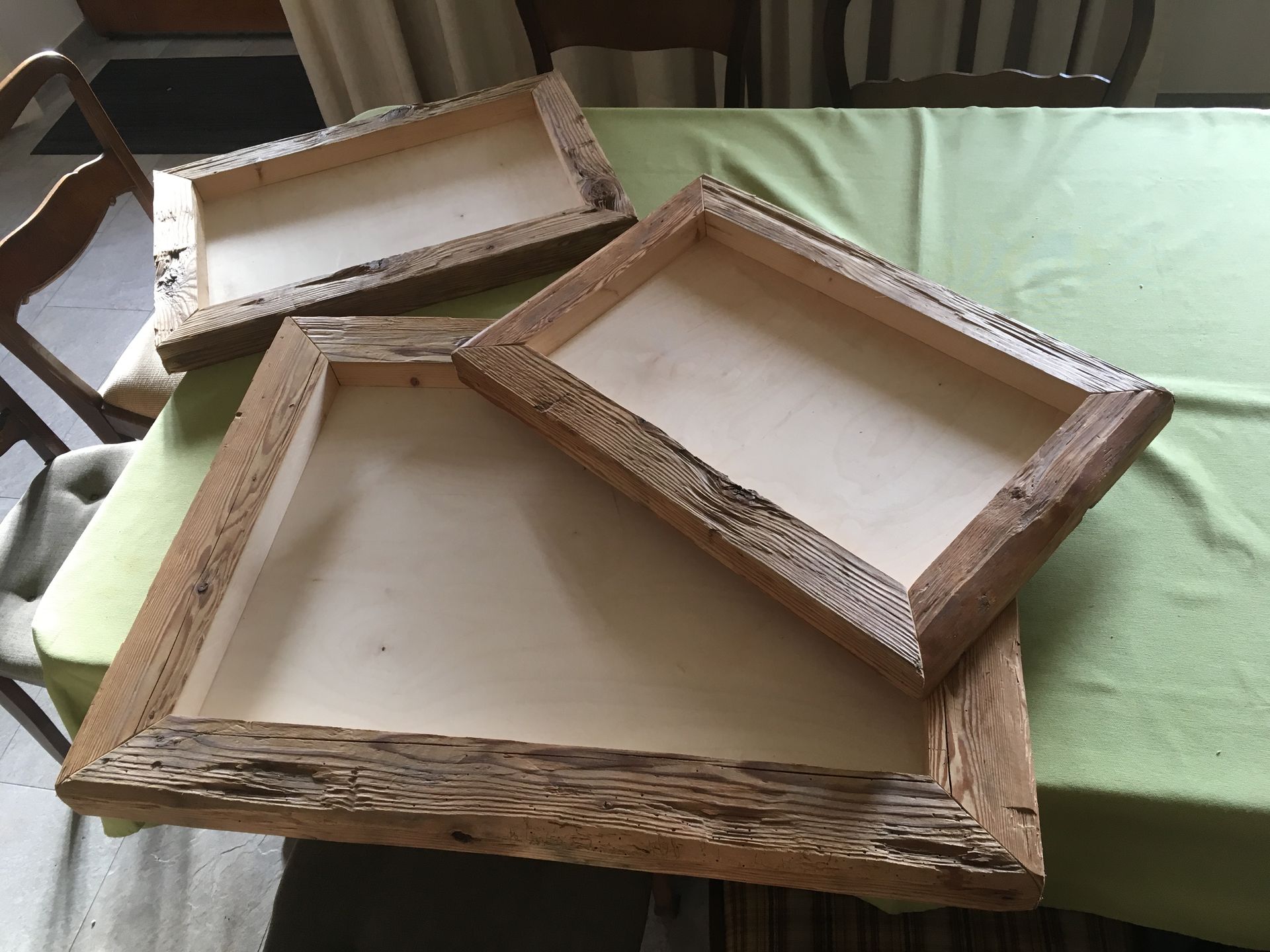 Mehrere handgefertigte Holzrahmen aus rustikalem Holz auf einem Tisch