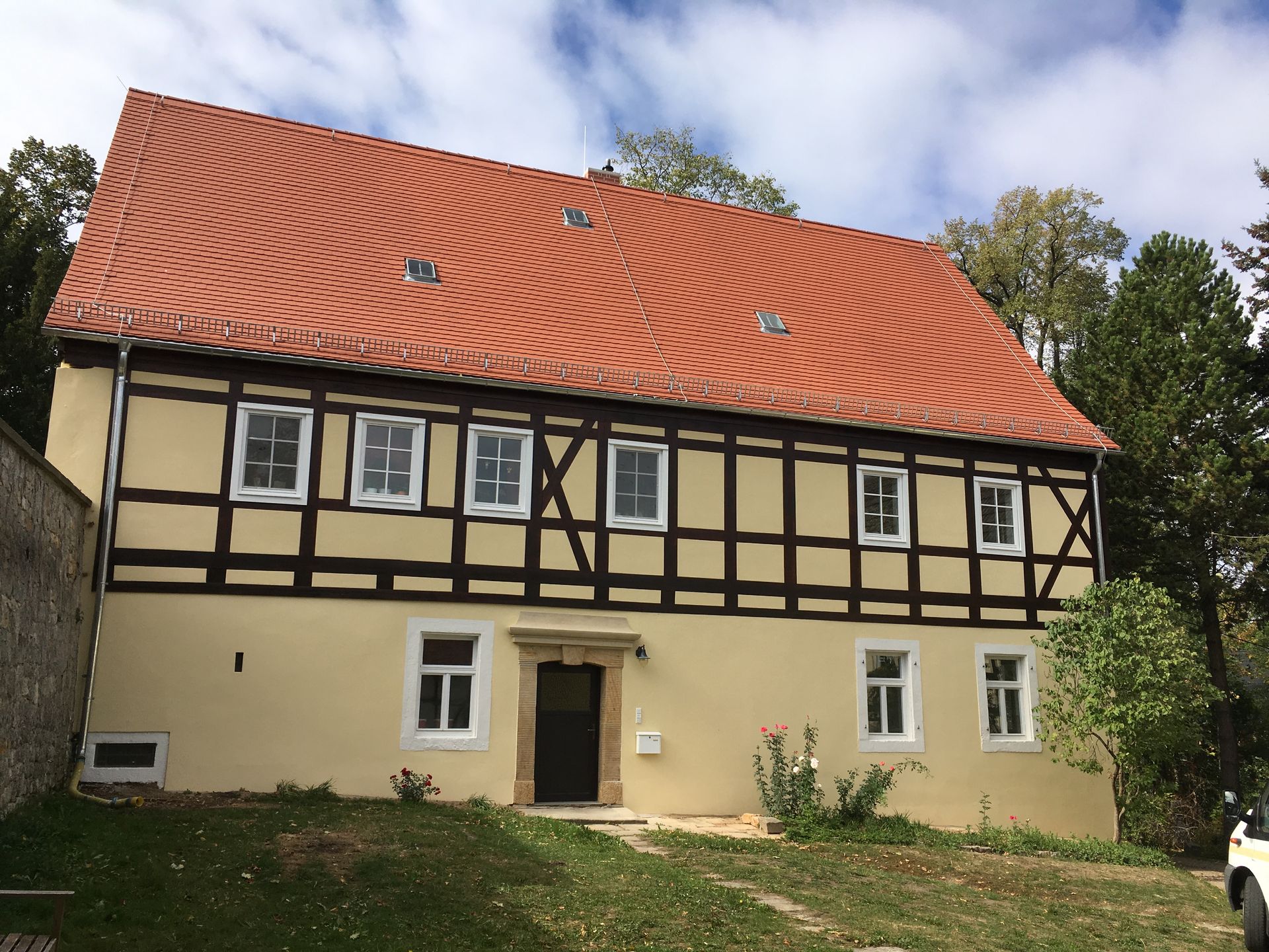 Historisches Fachwerkhaus mit rotem Ziegeldach nach Sanierung
