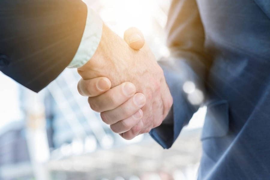 Dos hombres revisando documentos en un escritorio con un mazo y una balanza de justicia, probablemente en una oficina de abogados.