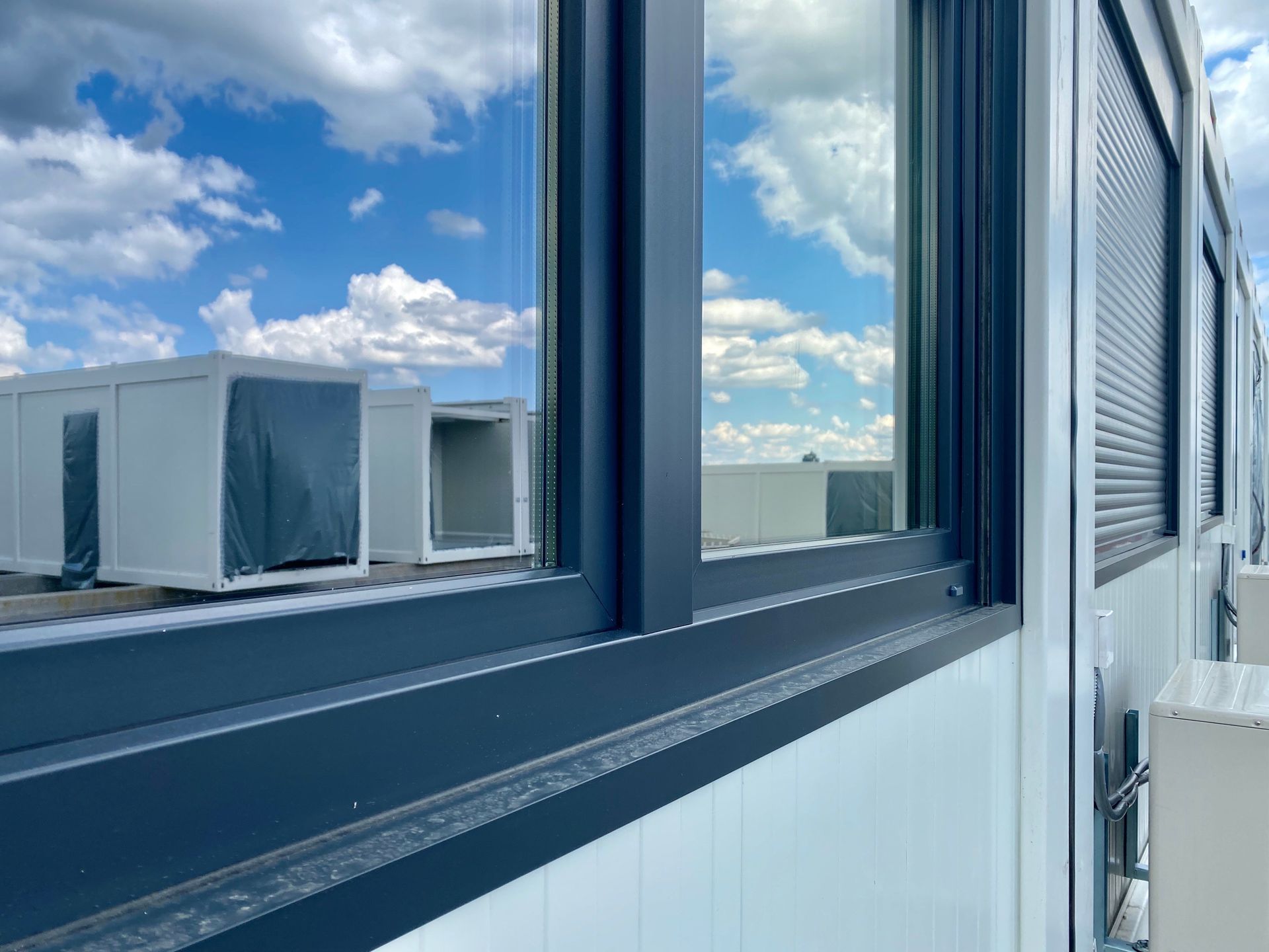 Reflets dans des vitres propres de bungalow sur un chantier.