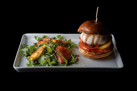 Un hamburger et des frites sont sur une planche à découper en bois.