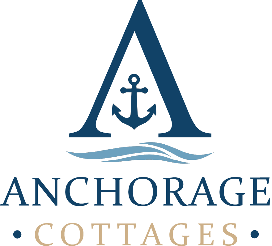 Anchorage Cottages logo with navy anchor in an “A” and blue waves above gold serif text