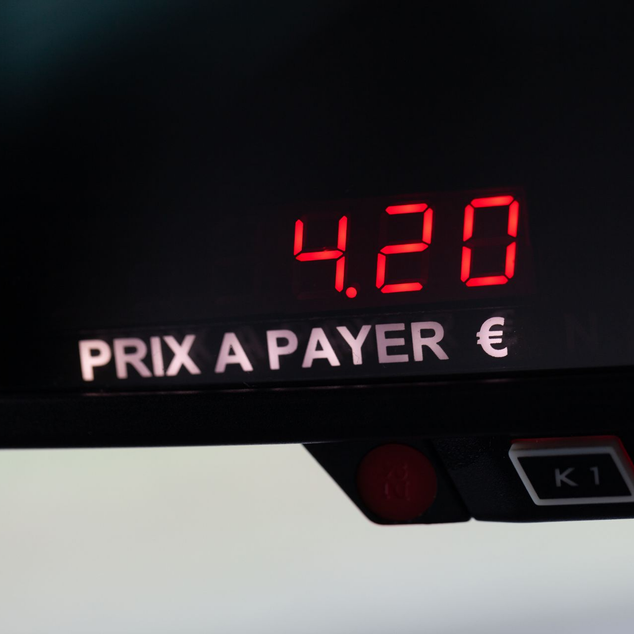 Panneau d'affichage à l'intérieur de la voiture indiquant 4,20 et prix à payer en chiffres rouges sur fond noir.