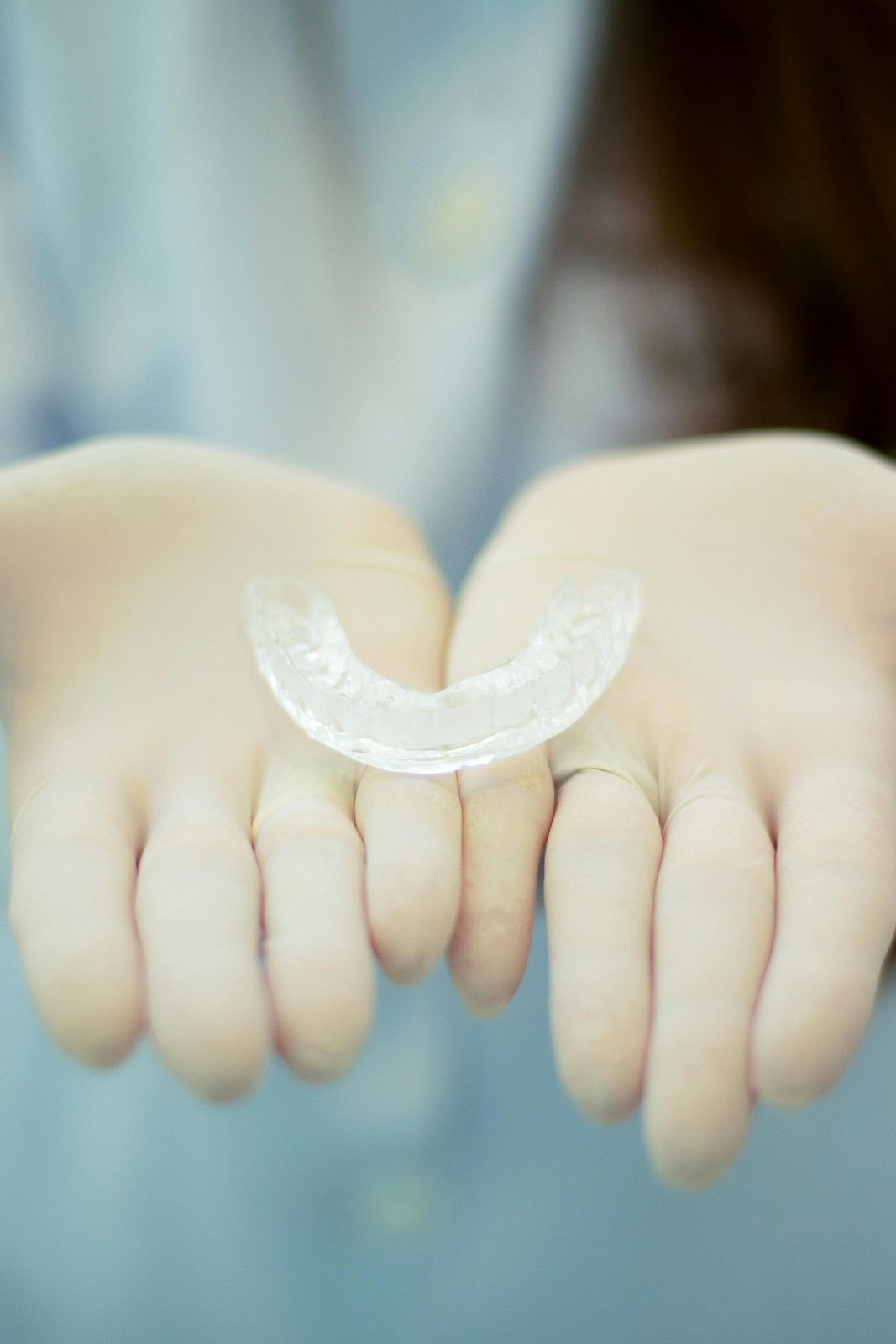 Alineador dental transparente apoyado sobre las manos ahuecadas