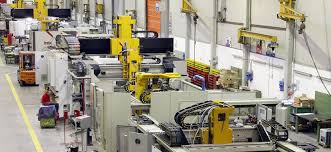 Une usine industrielle avec des bras robotisés et des machines en fonctionnement.