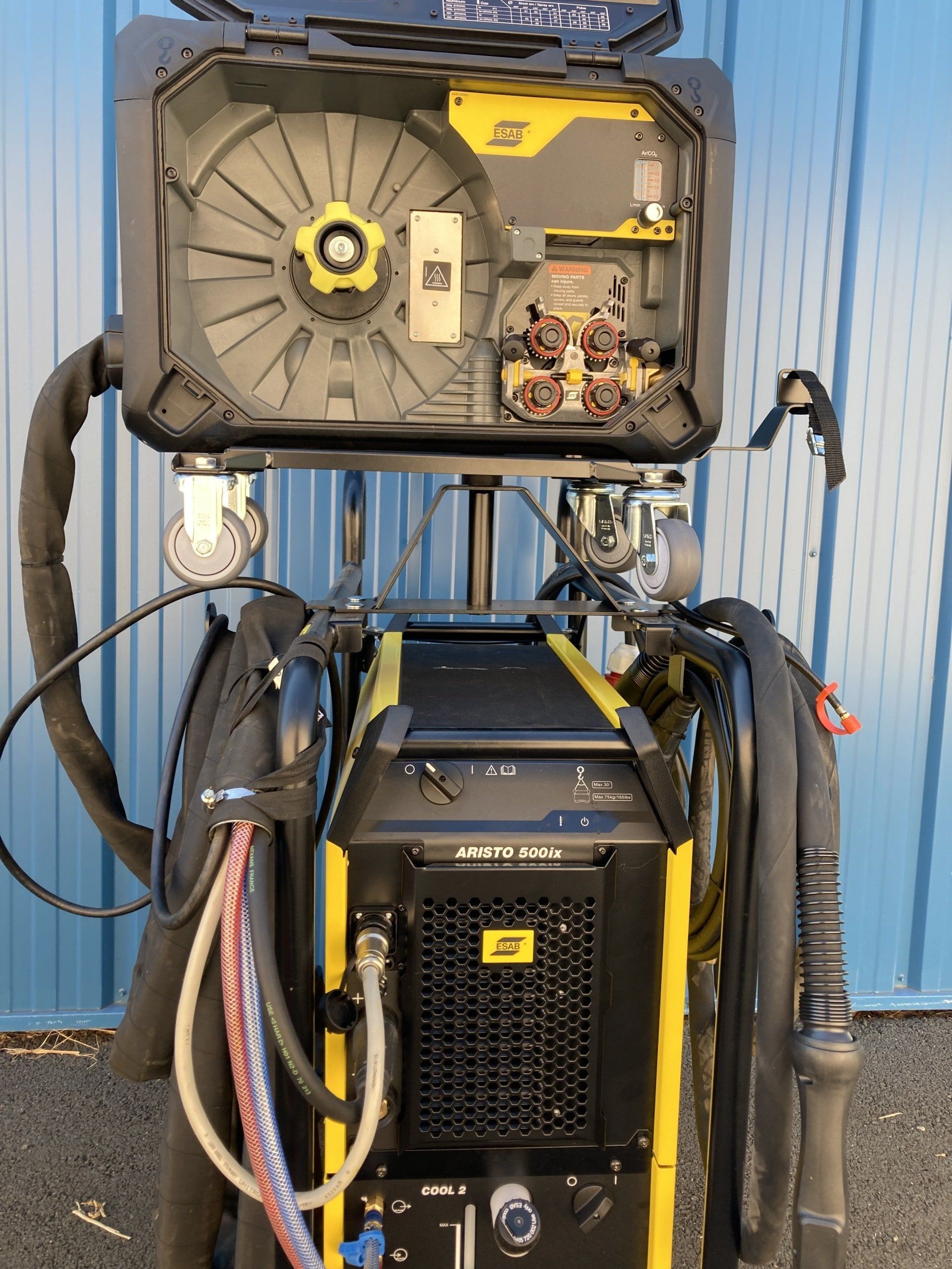 Machine à souder industrielle noire et jaune sur roues, avec panneaux d'accès ouverts.