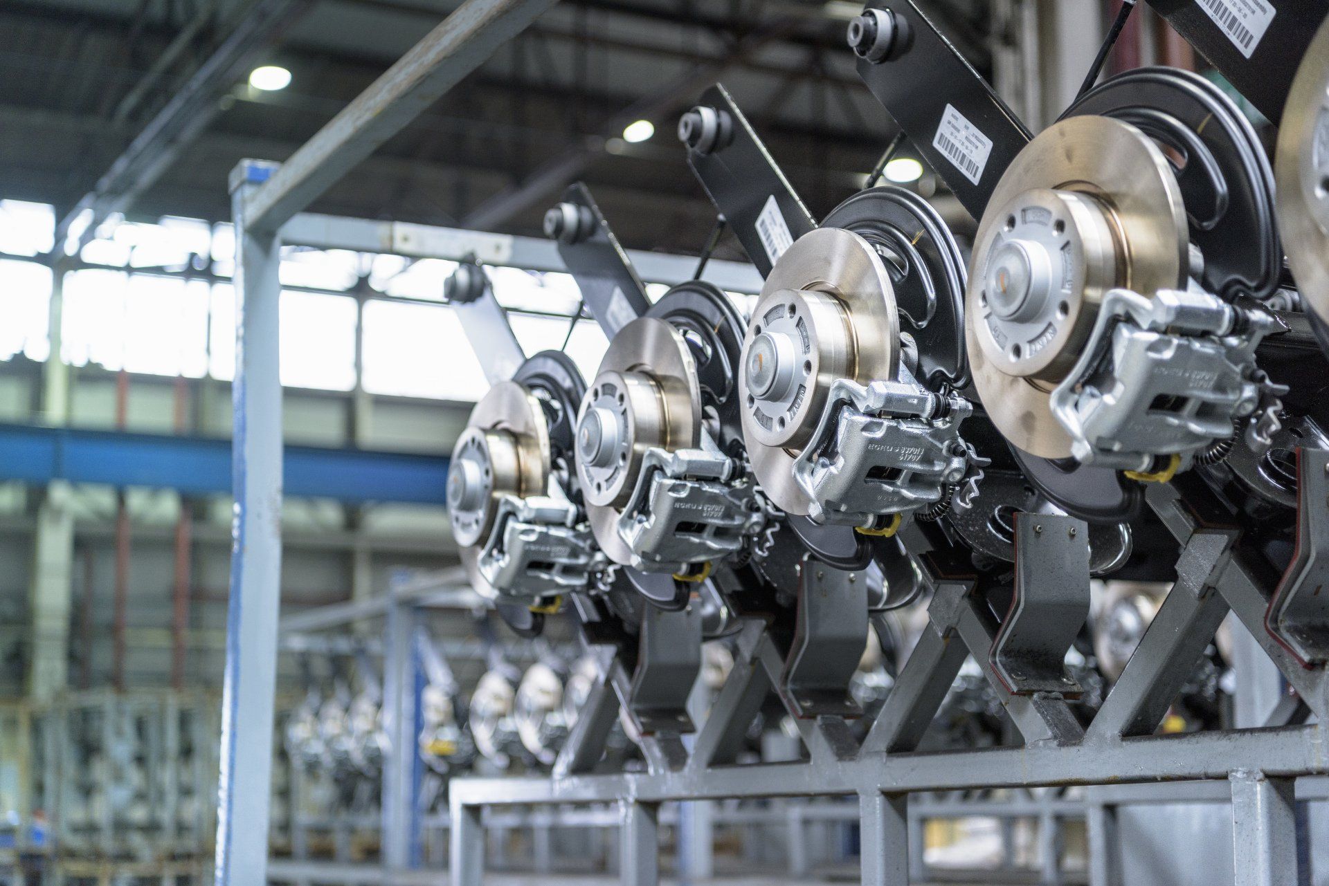 Ensembles de freins de véhicules sur rack en configuration usine, prêts à être installés.