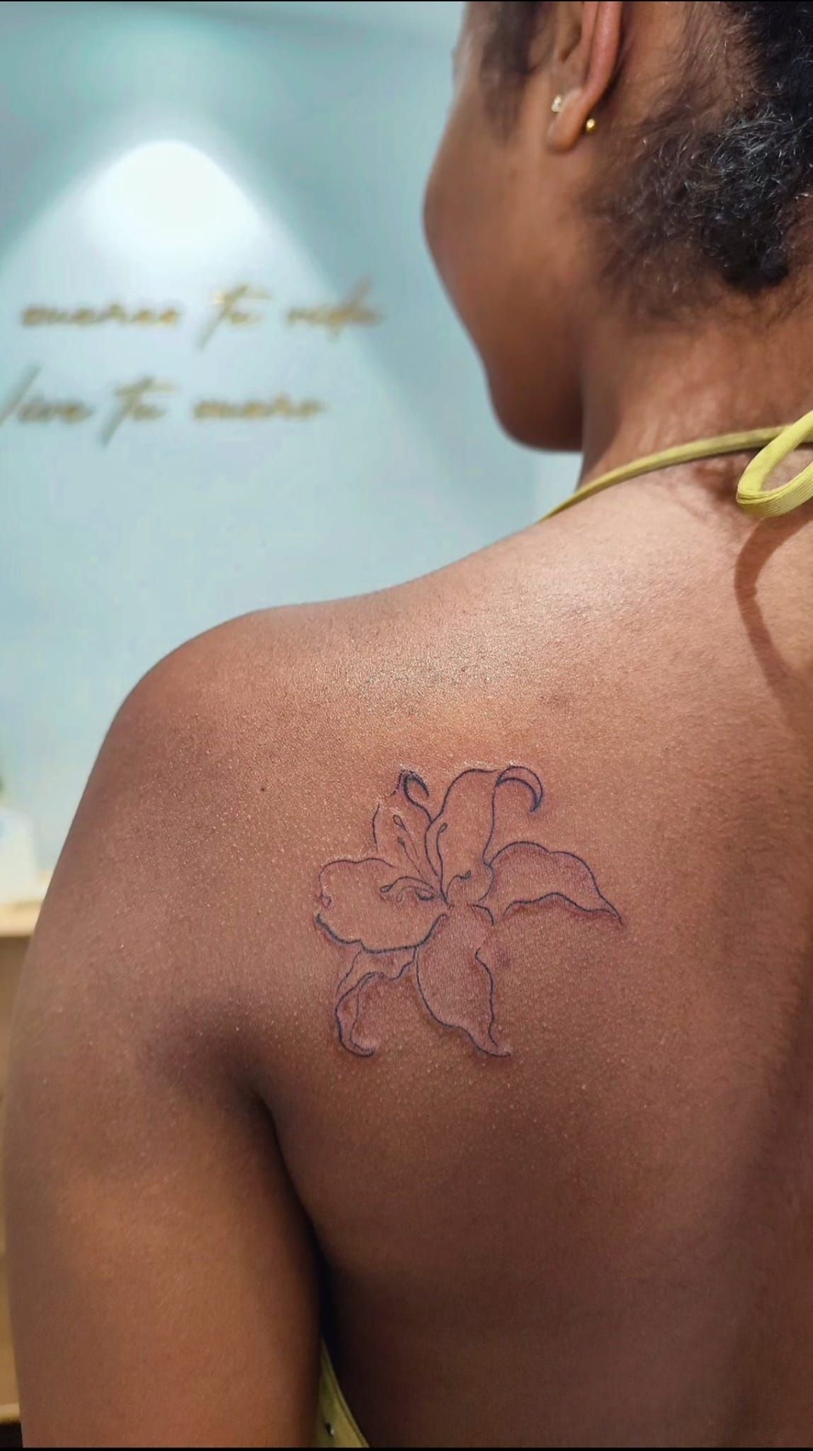 Primer plano del hombro y la parte superior de la espalda de una persona con un tatuaje oscuro.