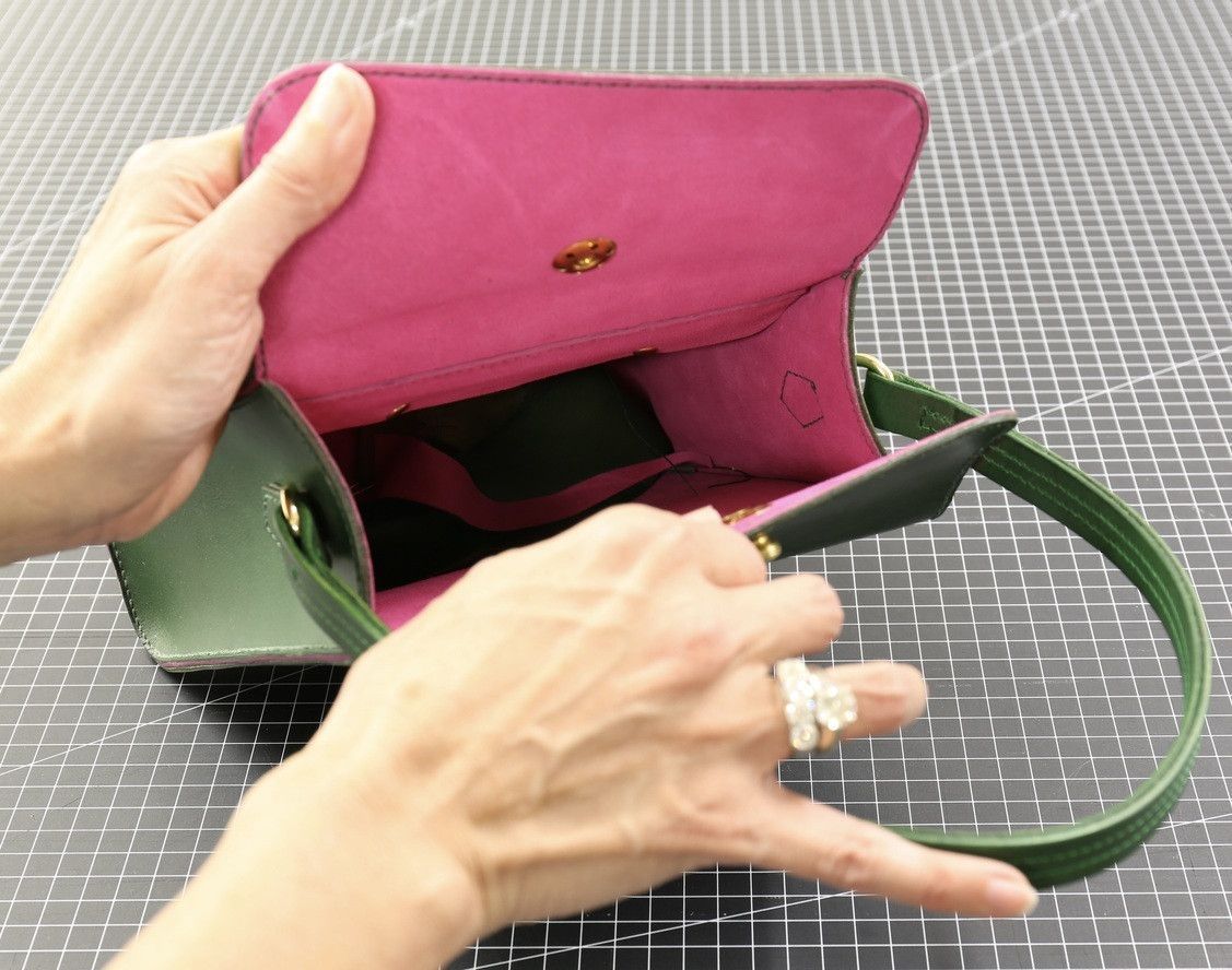 hands opening trapezois bag
