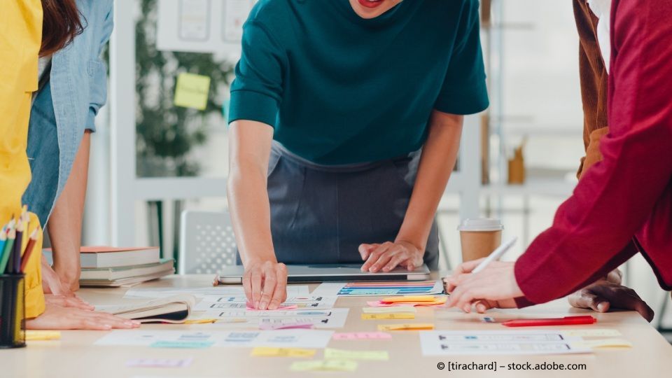 Media Service, Mann ordnet Post-its auf Tisch