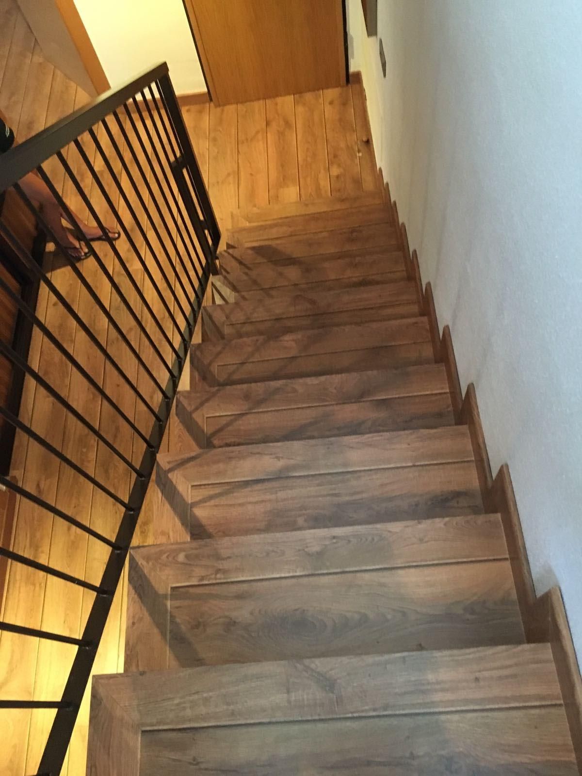 Un conjunto de escaleras de madera con barandilla de metal.