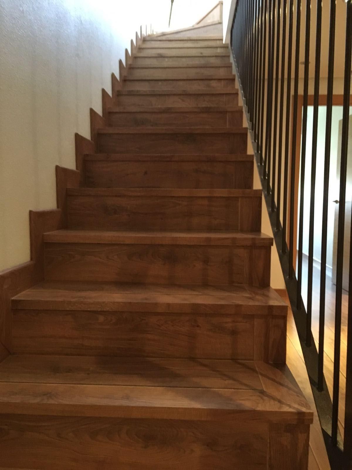 Una escalera de madera con barandilla de metal en una casa.