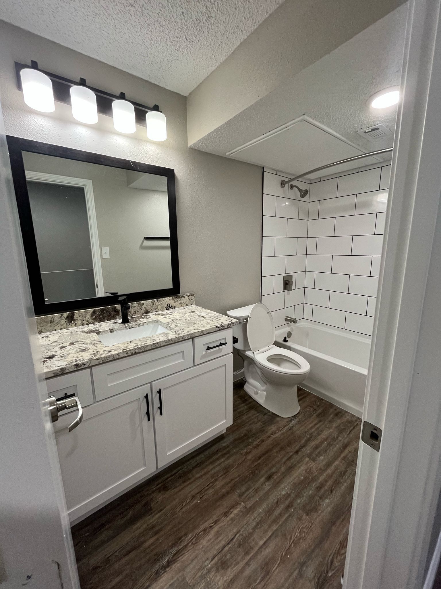 Un baño con inodoro, lavabo, espejo y bañera.