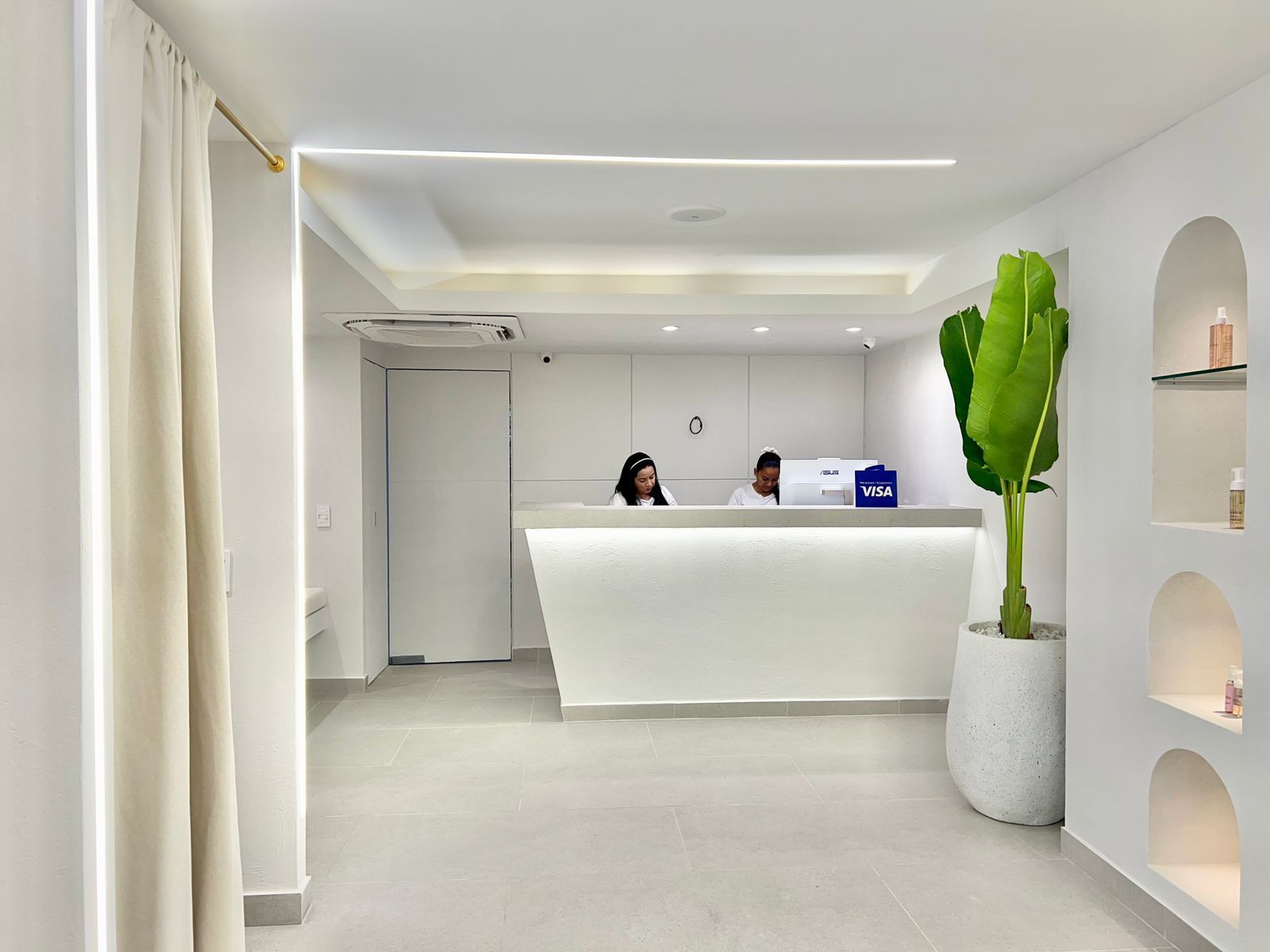 Una mujer está sentada en un mostrador en el vestíbulo de un hotel.