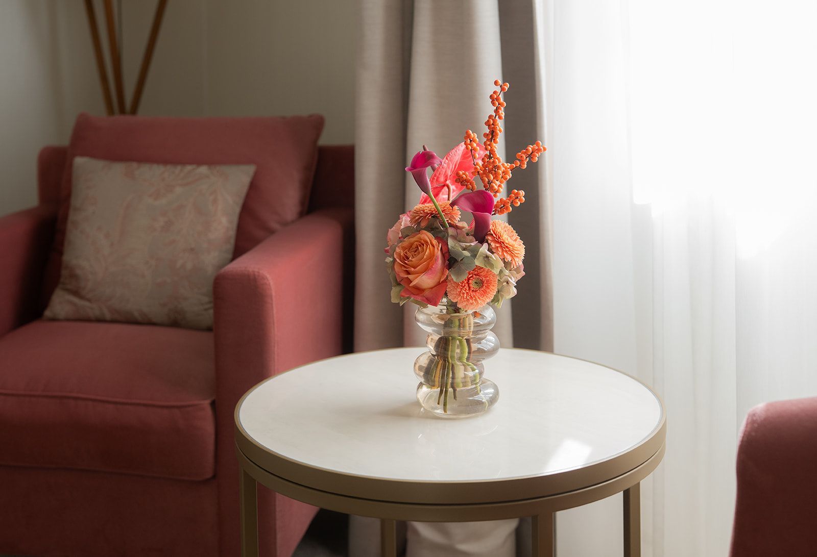 Zwei Personen in Bademänteln liegen mit hochgelagerten Beinen auf einem Bett und halten Champagnergläser in den Händen.