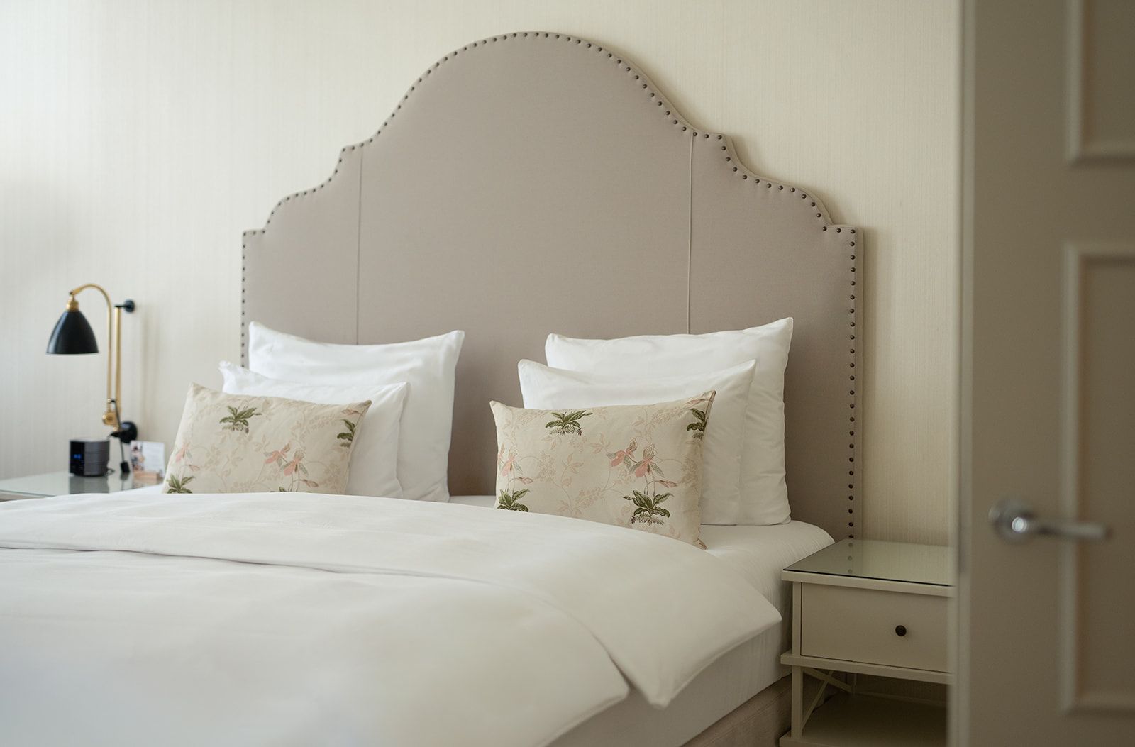 A cocktail in a fluted glass with ice and a lemon twist, served on a wooden surface.