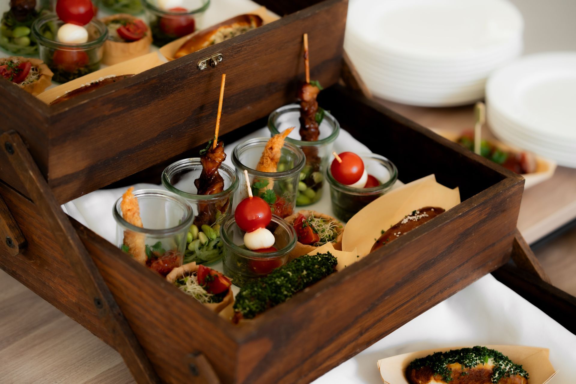 Ein Kellner hält in einem Restaurant zwei Teller mit Essen: Salat und Bruschetta.