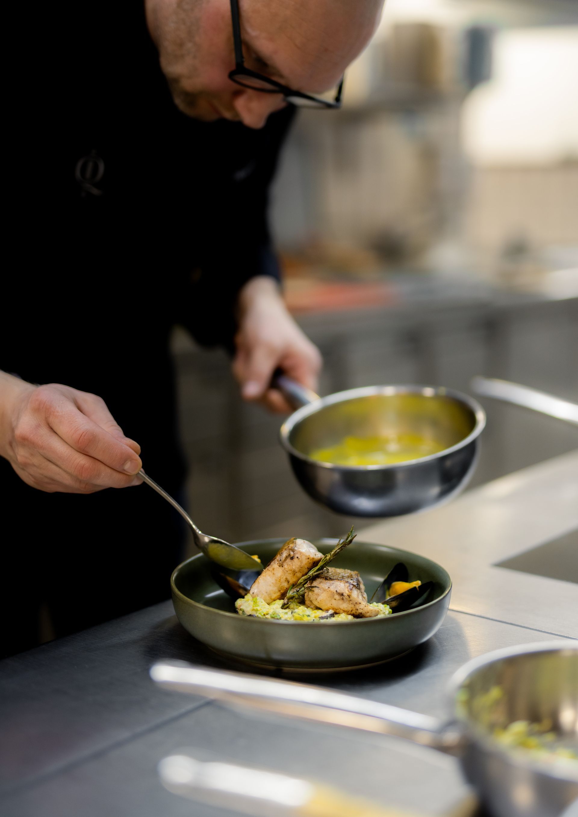 Cocktail in einem geriffelten Glas mit Eis und einer Zitronenzeste auf einer Holzoberfläche.