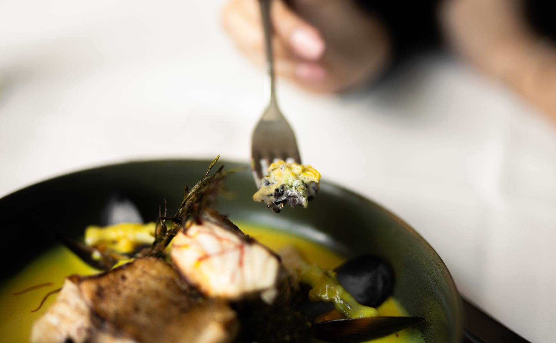Restaurantinterieur mit gedeckten Tischen, Fenstern und Kunstwerken.