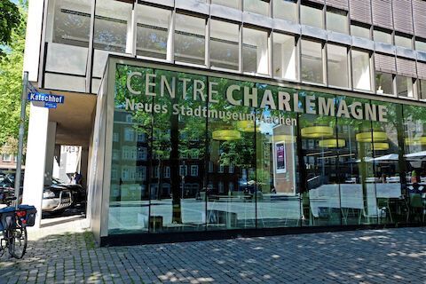 Das Centre Karl der Große Museum in Aachen, Deutschland, mit Glasfassade und Beschilderung.