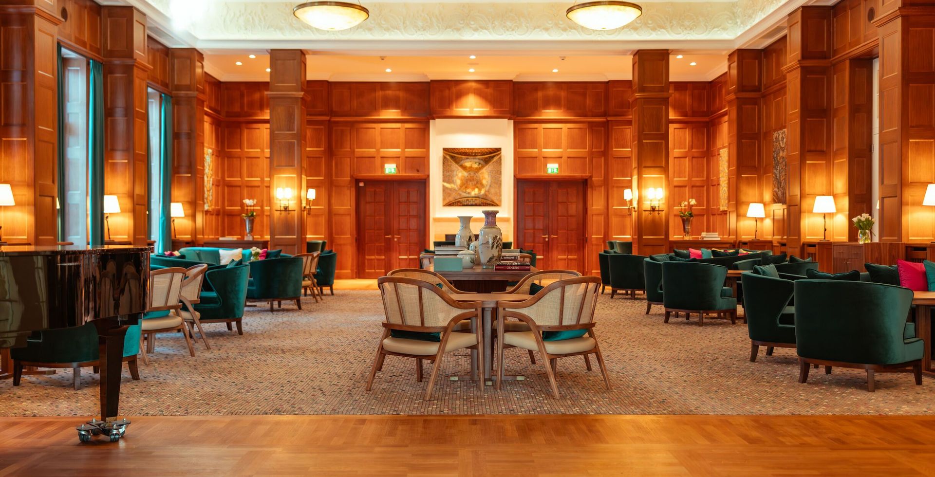 An elegant hotel lounge with wood paneling, velvet seats, and a grand piano.
