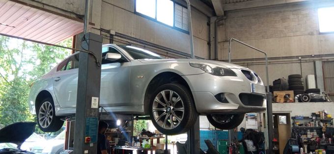 Un coche plateado está estacionado en un elevador en un garaje.