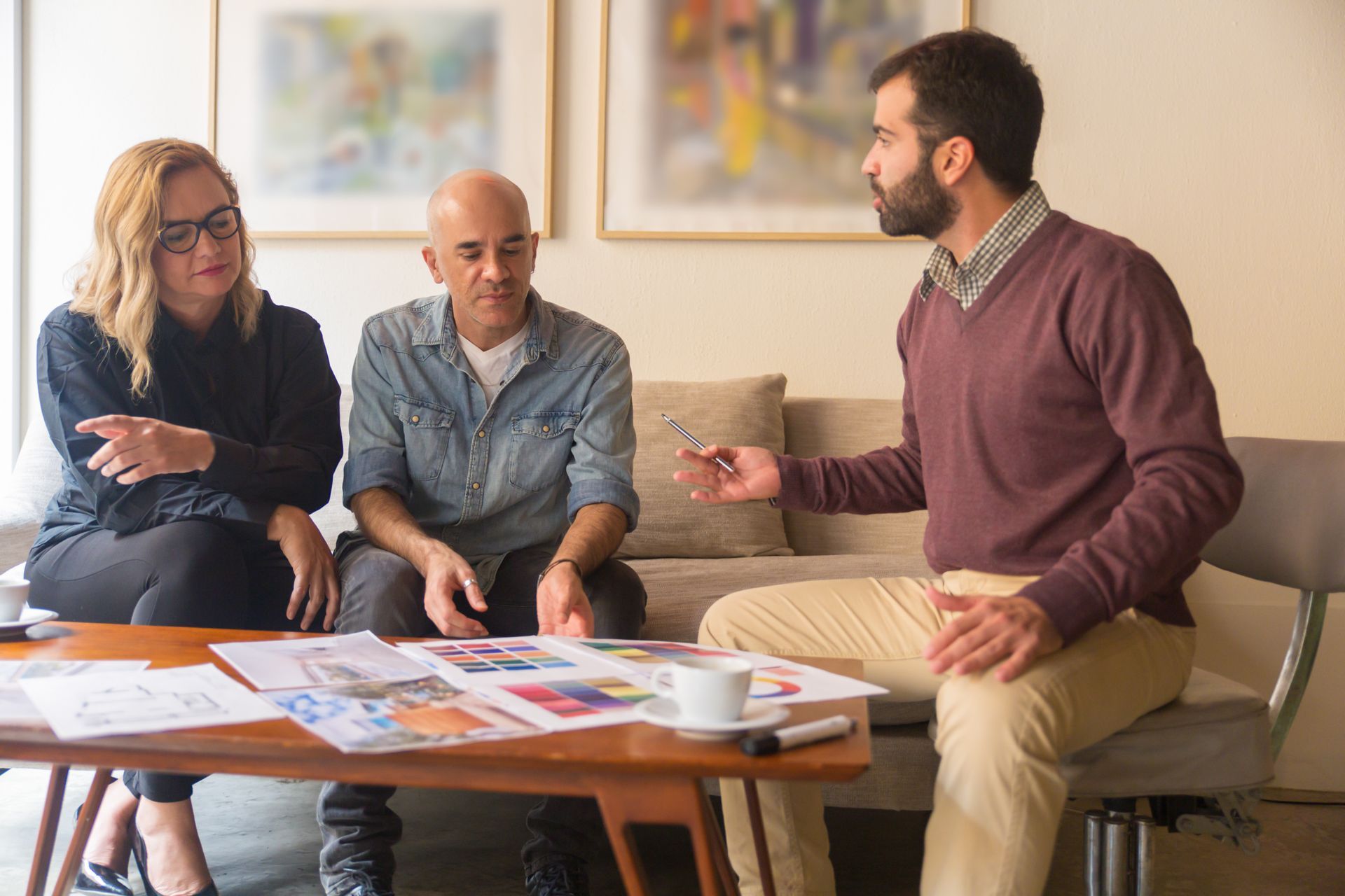 Un architecte discute du projet avec ses clients sur un canapé