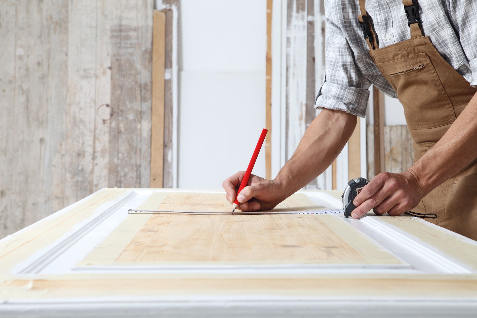 Un architecte prend les mesures d'un plan de travail en bois dans la cuisine