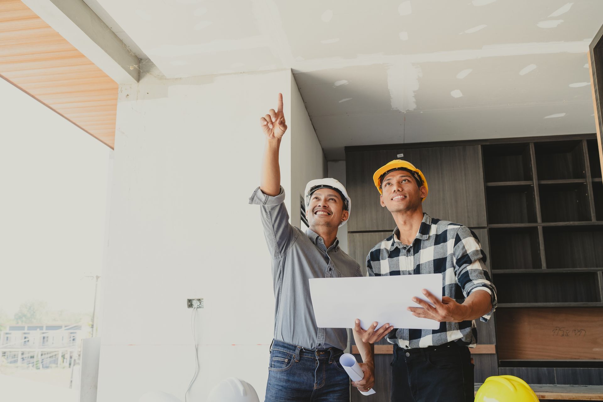 Deux architectes regardent un plan lors de la conception d'une chambre de la maison