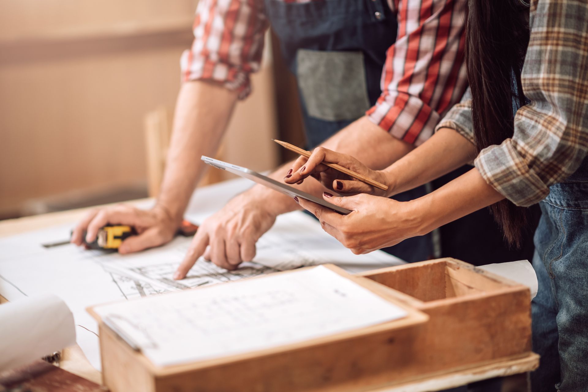 Deux architectes regardent ensemble une tablette et un plan