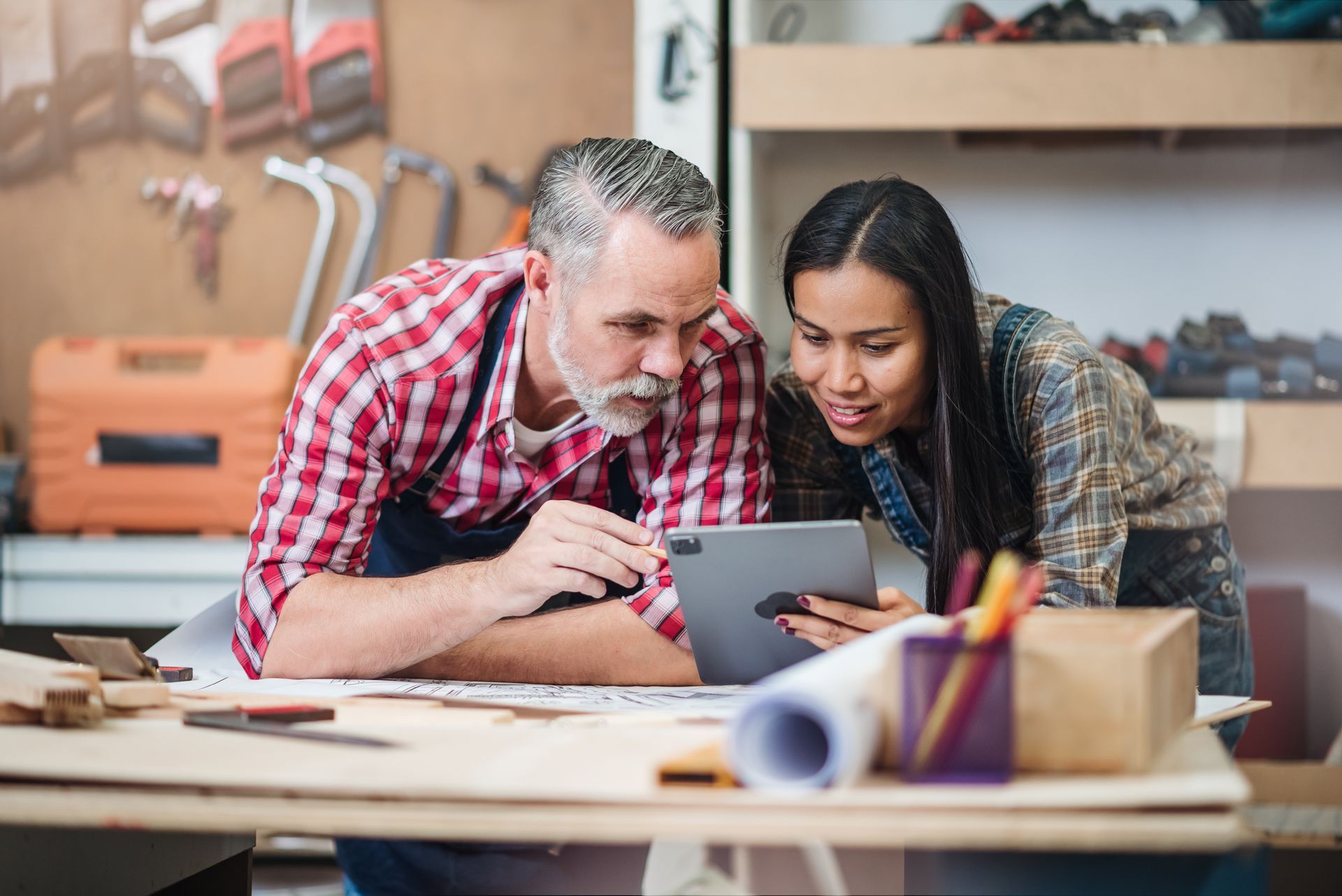 Deux architectes regardent une tablette lors de la conception d'une chambre de la maison