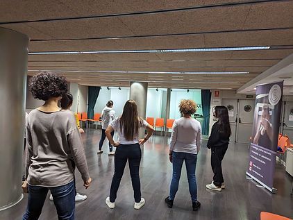 Un grupo de mujeres están paradas en círculo en una habitación.