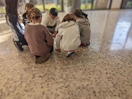 Un grupo de niños está sentado en círculo en el suelo.
