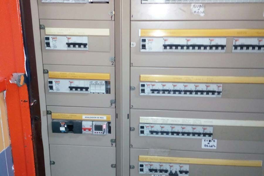 Cuadro eléctrico con numerosos disyuntores y contador.