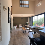 Un salon avec une table, des chaises et un banc.