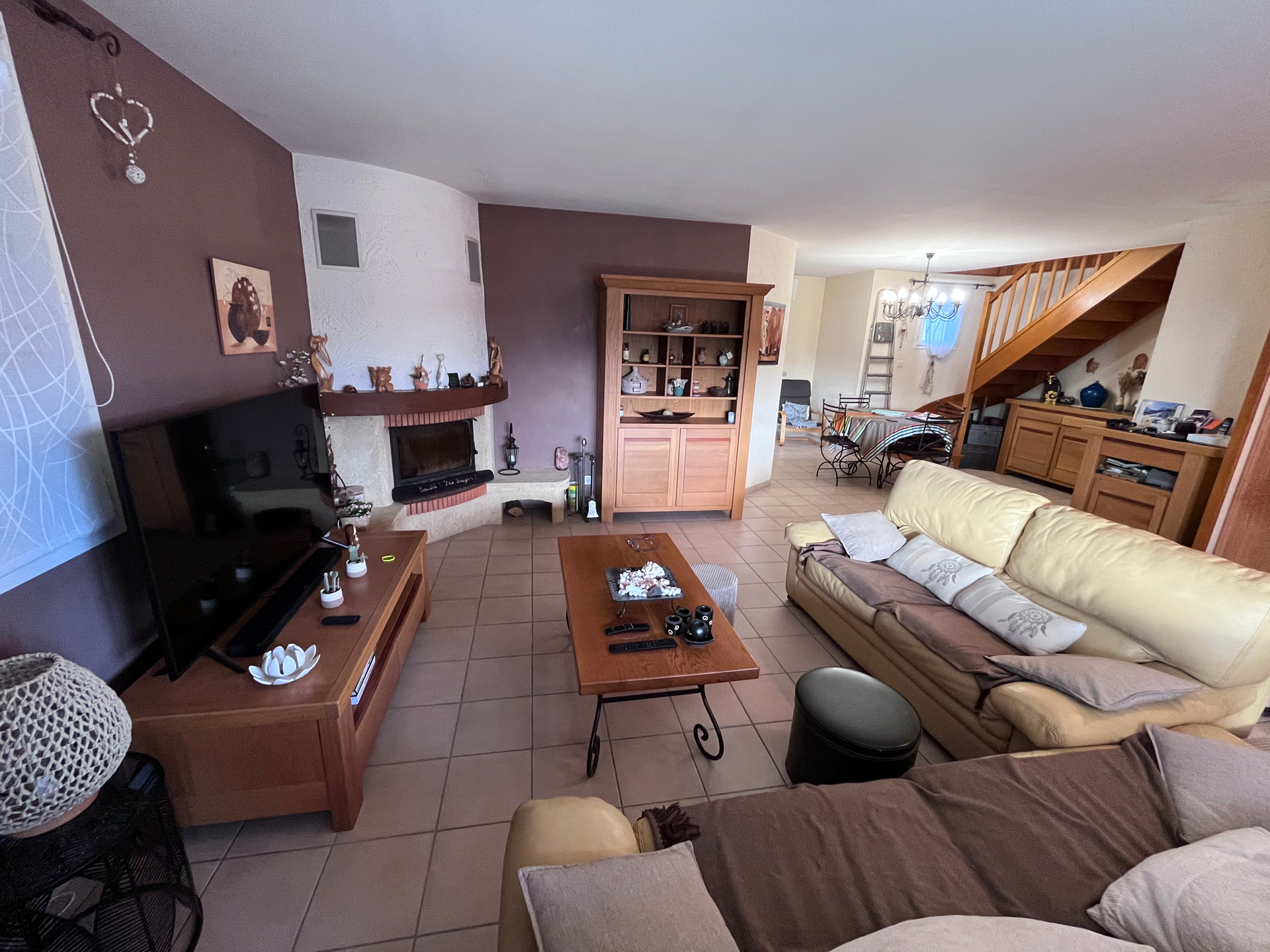 Un salon avec un canapé, une télévision et une cheminée