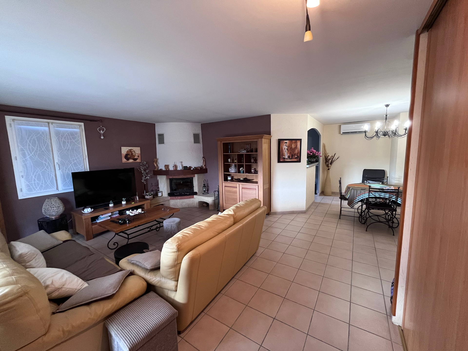 Un salon avec un canapé, une télévision et une cheminée