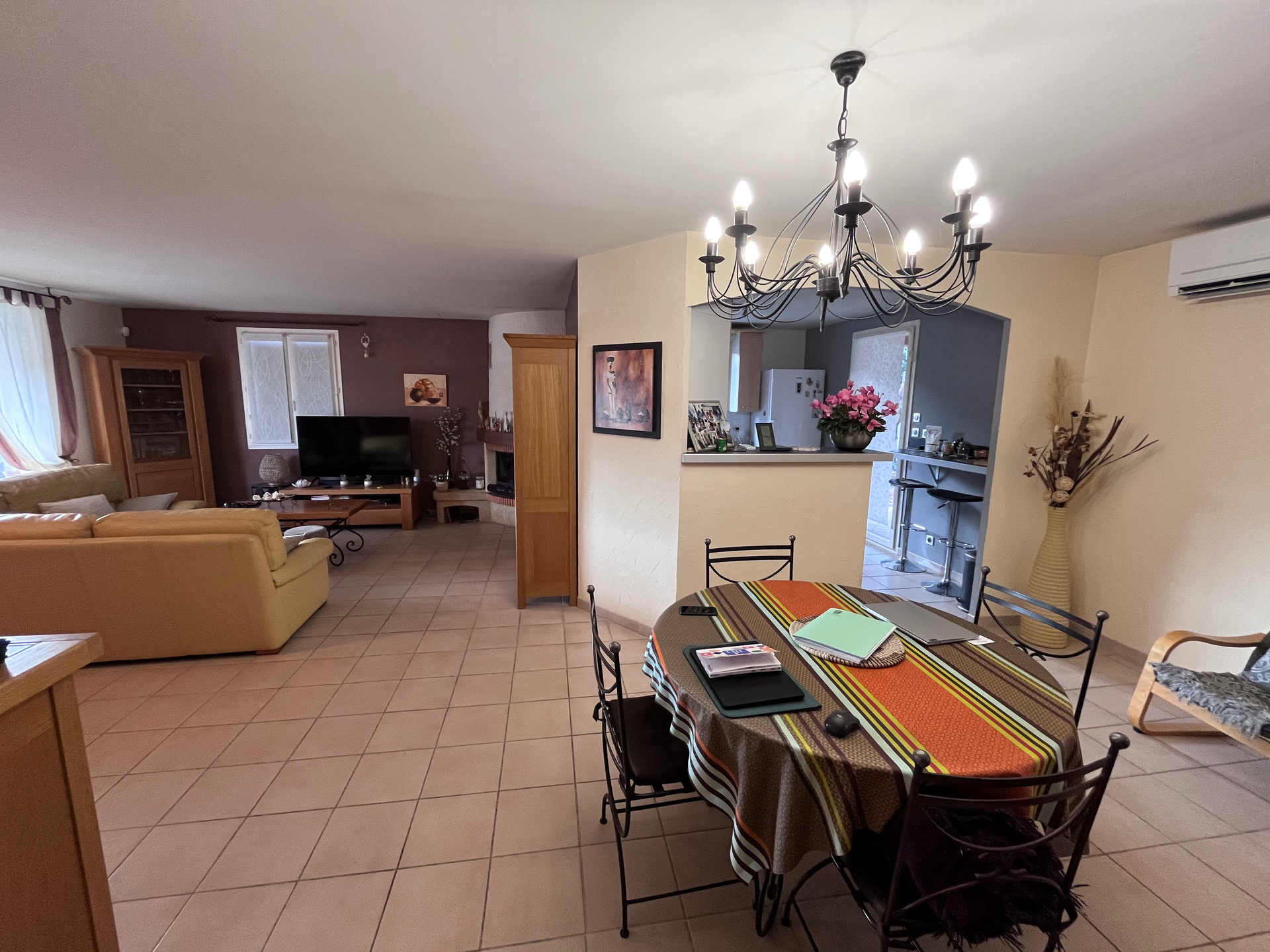 Un salon avec une table, des chaises et un lustre