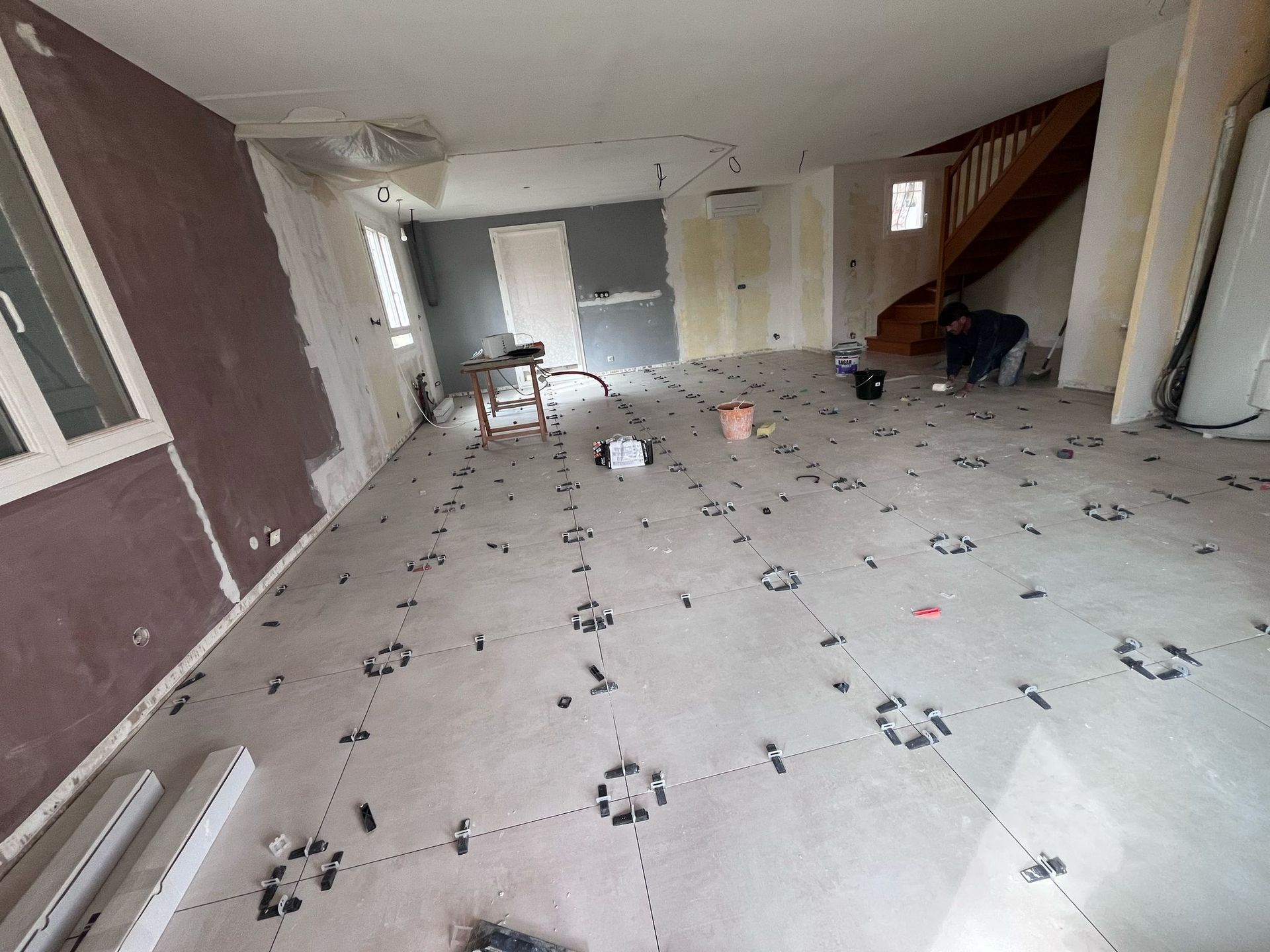 Une pièce avec un escalier et beaucoup d'empreintes de pas sur le sol