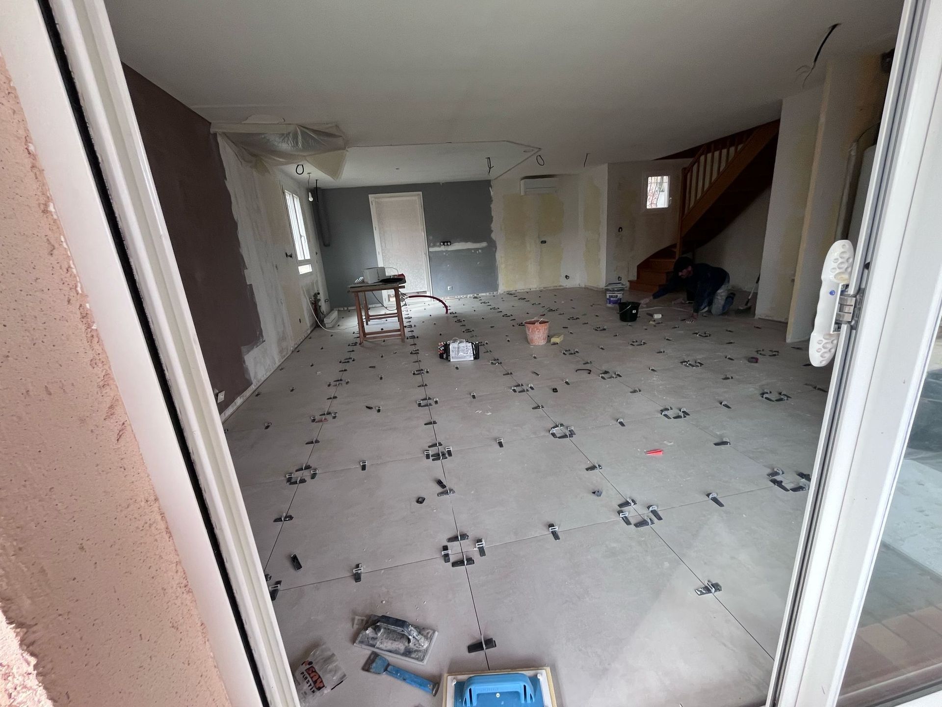 Une pièce avec un escalier et beaucoup de carrelage au sol