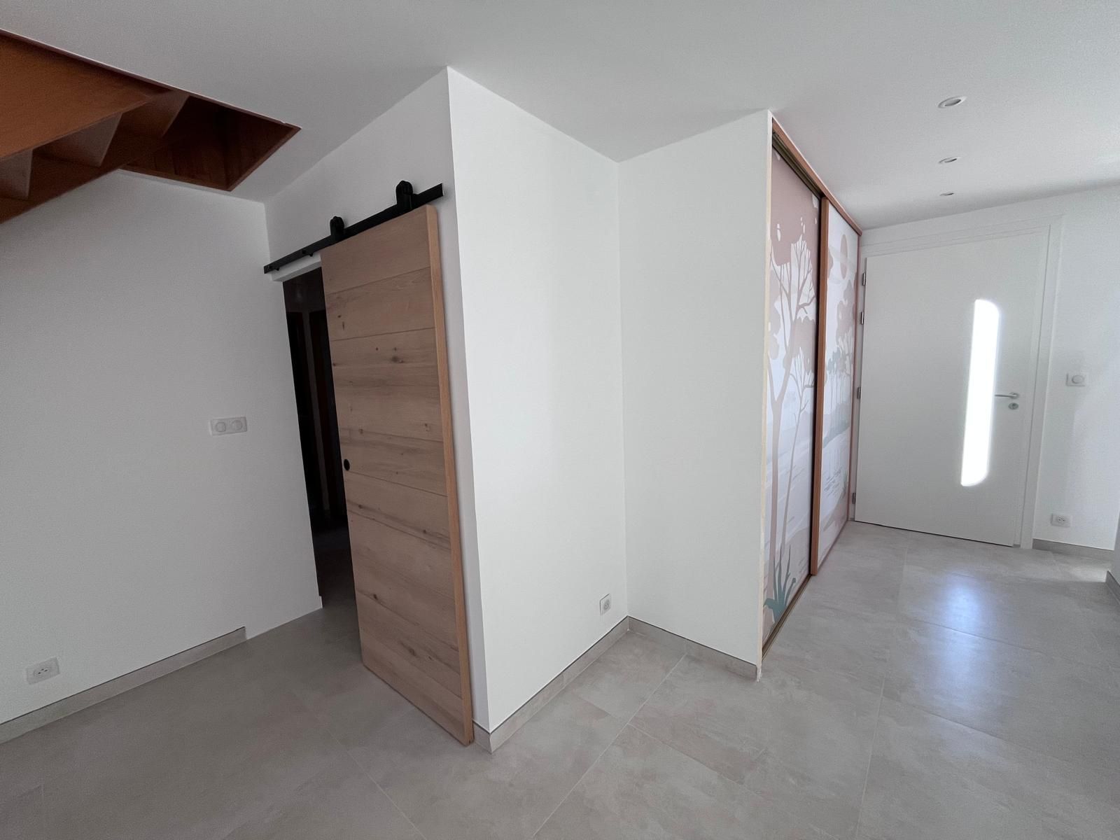 Une pièce vide avec un escalier et une porte coulissante